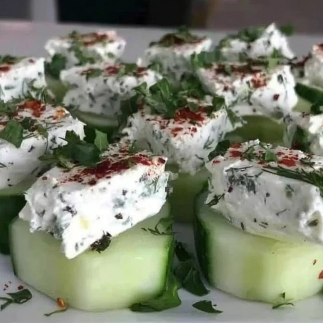 Delicious stuffed cucumber bites garnished with herbs and served on a platter